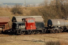 MH 302 photographed at the shunting yard in Fredericia, 3. March 1976.  Built by Frichs, Denmark in a number of 120. The class was put in service in 1960 - 1965. C0. Dieselhydraulic 8-cyl MAN engine. 440 hp. Max speed 60 km/h - 37 mph. Length 9 440 mm. Weight 45 metric tonnes. MH 302 was put in service in 1960. Withdrawn from service in 1998. The same year sold to Struer Jernbaneklub (Museumrailway) where it still remains in service.